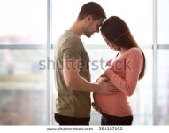 stock-photo-pregnant-woman-with-husband-in-front-of-the-window-384127192.jpg