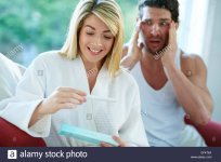 happy-girl-finding-out-she-is-pregnant-with-upset-man-in-background-EFK76A.jpg