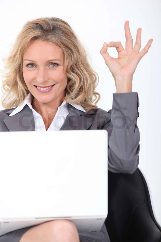 8067075-blonde-businesswoman-with-a-laptop-giving-the-ok-sign.jpg
