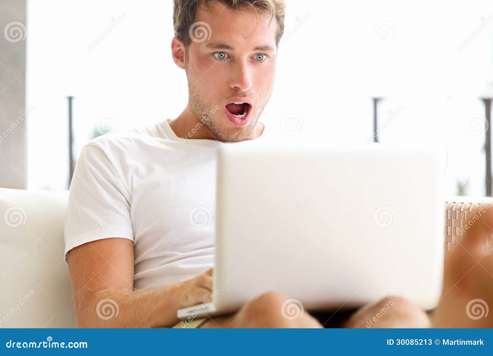 shocked-surprised-man-looking-laptop-computer-surprised-amazed-open-mouth-big-eyes-funny-young-male-model-sitting-outside-sofa-30085213.jpg